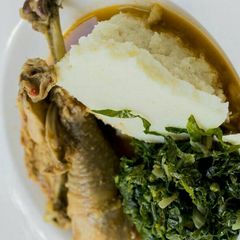 A picture of Stewed Chicken and Ugali with kales.