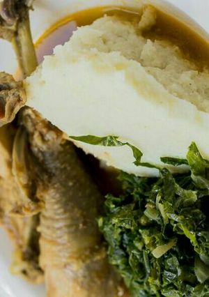 A picture of Stewed Chicken and Ugali with kales.