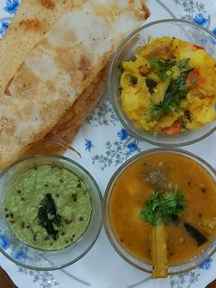 A picture of South Indian cuisine platter(dosa,sambar,chutney,potato veggie).