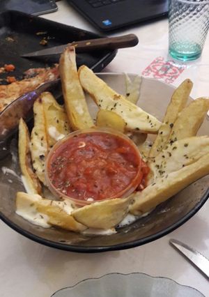 Una foto de Papas rústicas con salsa y queso