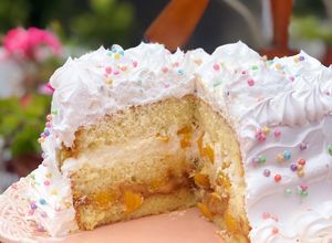 Una foto de Bizcochuelo relleno, con dulce de leche, crema y duraznos