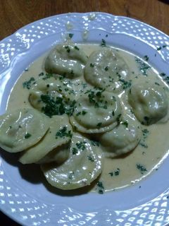 Una foto de Sorrentinos de camarones, mozzarella, ajo y perejil y salsa de 4 quesos