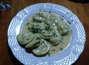 Una foto de Sorrentinos de camarones, mozzarella, ajo y perejil y salsa de 4 quesos