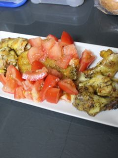 Una foto de Alitas de pollo con patata y tomate