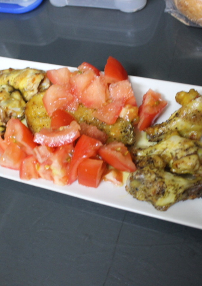 Una foto de Alitas de pollo con patata y tomate