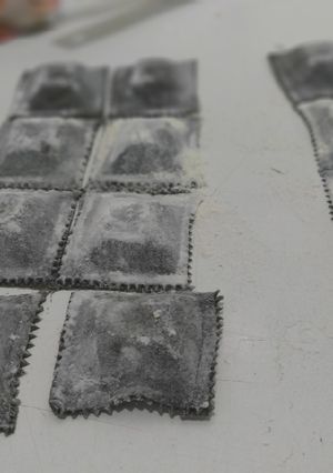 Una foto de Ravioles rellenos de pescado con masa de tinta de calamar