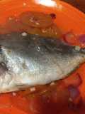 Dorada al horno sobre cama de tomate y al limón