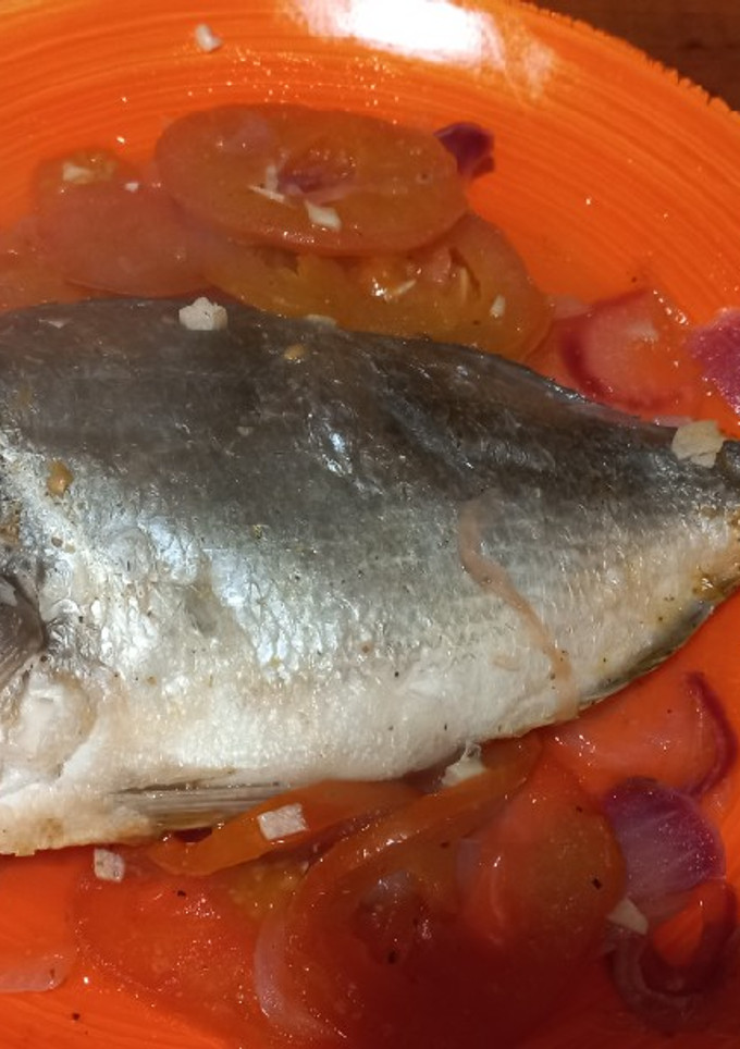 Una foto de Dorada al horno sobre cama de tomate y al limón