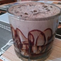 A picture of Cold coffee with cinnamon powder.