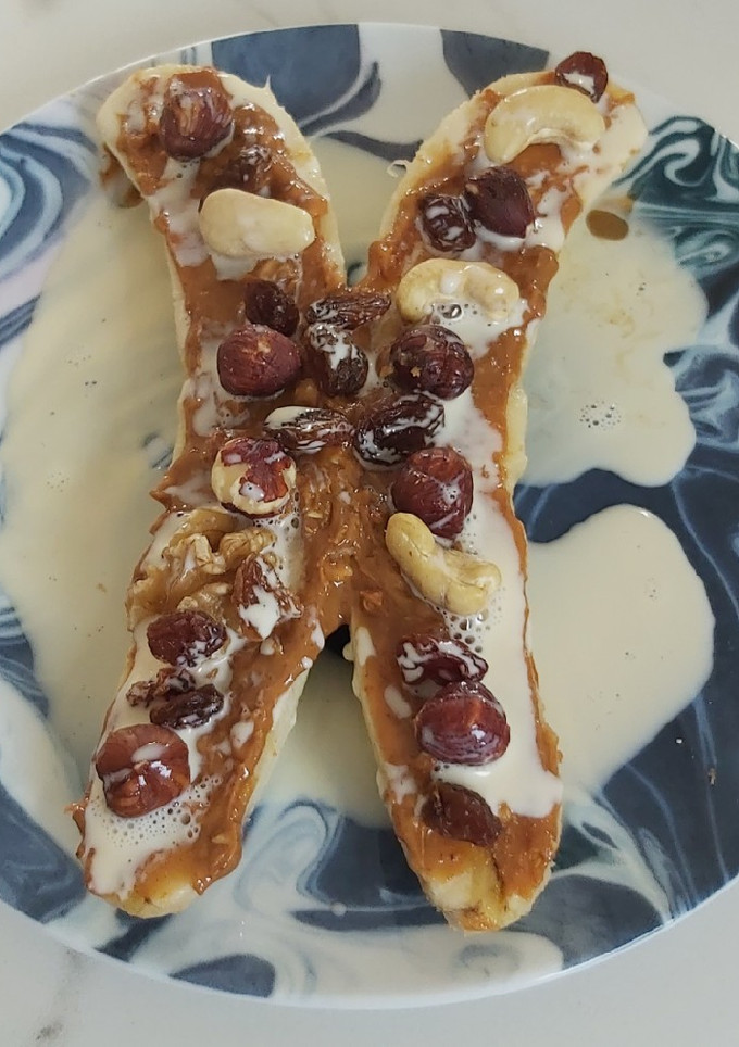Una foto de Plátano con mantequilla de maní, leche condensada y frutos secos