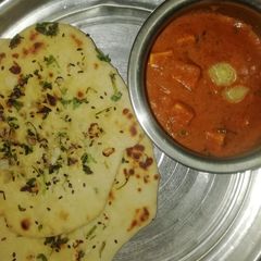 A picture of Garlic butter naan and paneer butter masala.