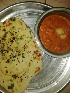 A picture of Garlic butter naan and paneer butter masala.