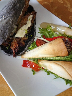 Una foto de Bocata de calamares con pan negro con tinta de calamar y cucuruchos de calamares con ensalada