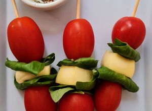 Una foto de Pinchos o brochetas caprese 🍢 albahaca, tomate, queso y oliva