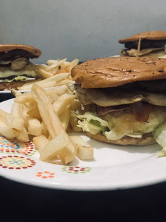 Una foto de Hamburguesa de Pollo y Res con cebolla caramelizada