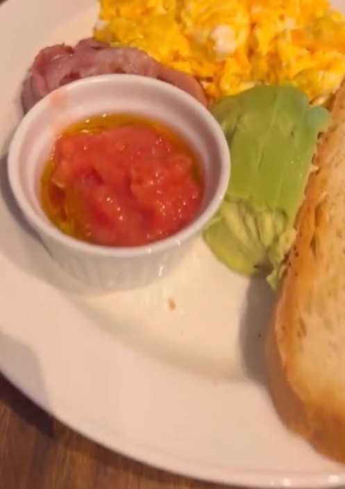 Una foto de Tosta de aguacate, tomate, huevo revuelto y jamón serrano