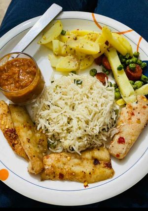 A picture of Baked fish with garlic rice sauté vegs and morrocon sauce.
