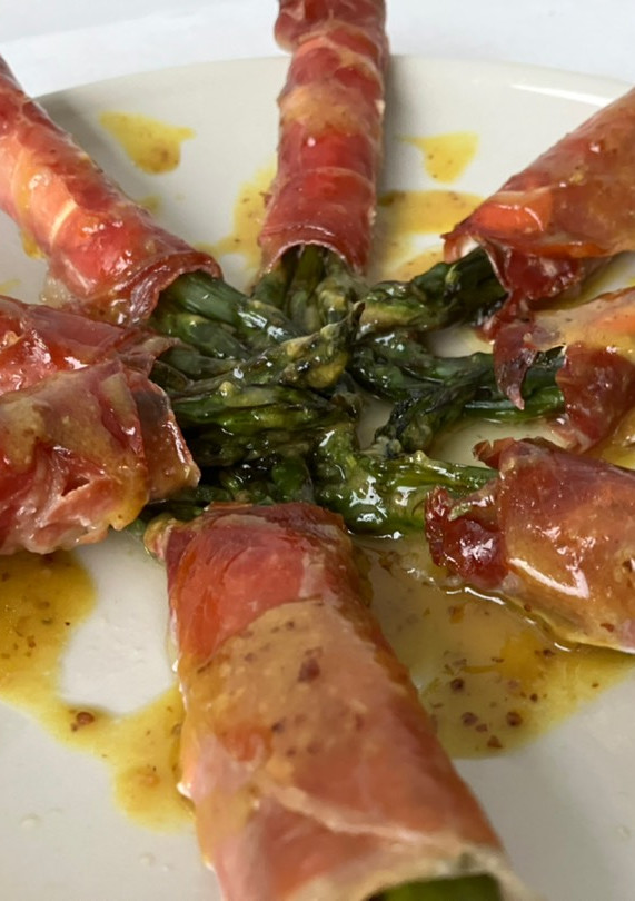 Una foto de Espárragos al horno con gabardina de jamón serrano y queso
