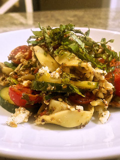 A picture of Tortellini olive tapenade with marinated tomatoes and cucumbers.