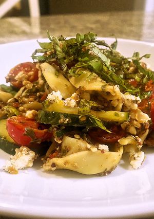 A picture of Tortellini olive tapenade with marinated tomatoes and cucumbers.