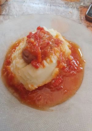 Una foto de Chorizo a la pomarola con puré de papas