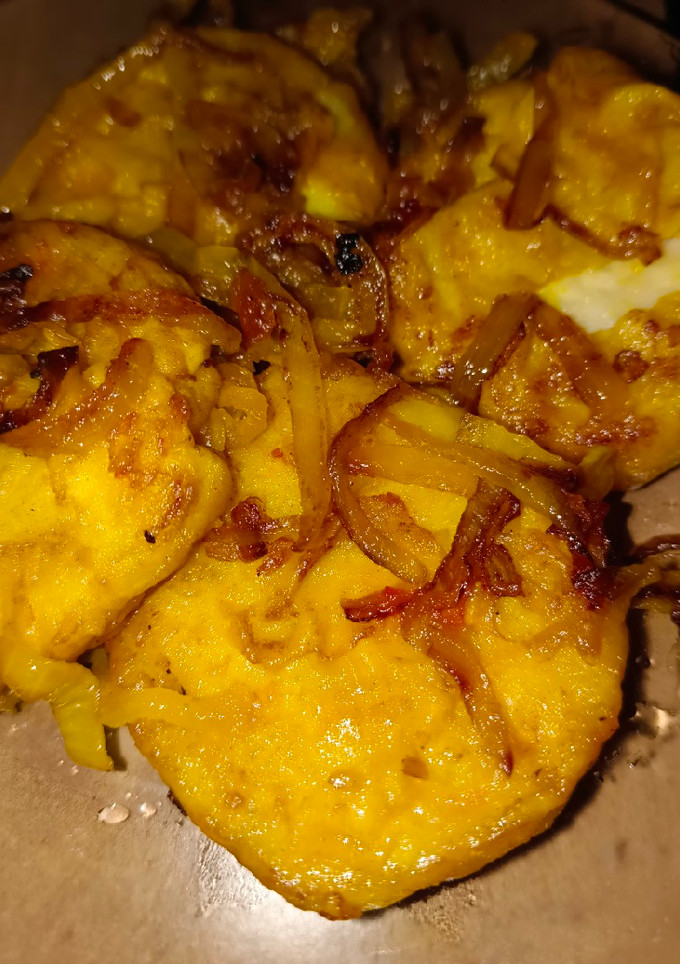 Una foto de Merluza encebollada en amarillo