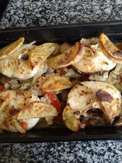 Una foto de Merluza al horno con tomate cebolla y patatas panadera