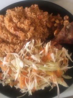 A picture of Jollof Rice with salad,pan fried shrimps with fried chicken.