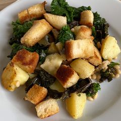 A picture of Cornish new potatoes with kale, Buttered croutons, pine nuts and Cornish blue cheese.