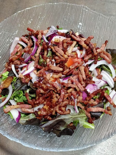 Una foto de Ensalada de brotes tiernos y bacon