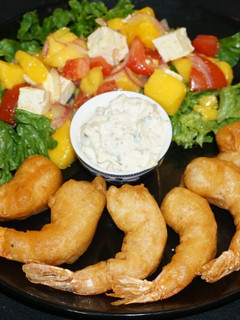 Una foto de Camarones fritos con batido de cerveza y ensalada de mango con queso de cabra