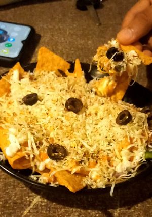 A picture of Nachos with cheese sauce.
