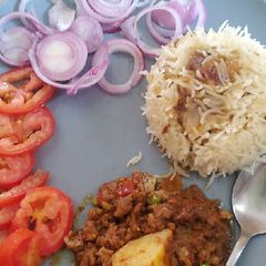 A picture of Karahi qeema matar with brown onion rice.