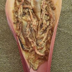 A picture of Banana flowers dip in mustard seeds.