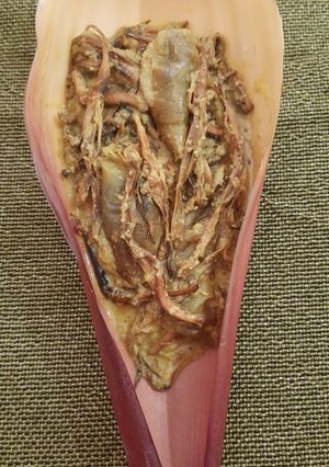 A picture of Banana flowers dip in mustard seeds.