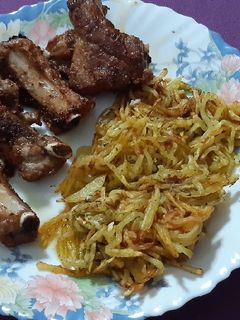 Una foto de Costillas de cerdo con patatas paja al ajillo