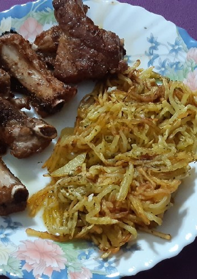 Una foto de Costillas de cerdo con patatas paja al ajillo