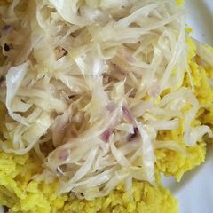 A picture of Fried cabbage with yellow rice.