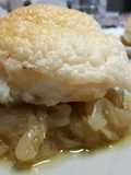 Bacalao cubierto de muselina de ajo sobre cebolla caramelizada