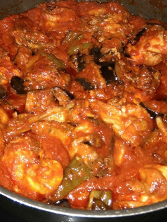 Una foto de Conejo con tomate, pimiento y berenjena
