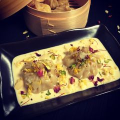 A picture of Kalakand Momo drizzled with Rabdi.