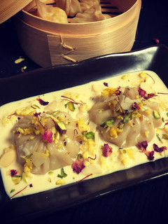 A picture of Kalakand Momo drizzled with Rabdi.