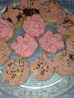 Una foto de Cupcakes relleno de crema de vainilla cubiertos con frosting de chocolate y mousse de fresa