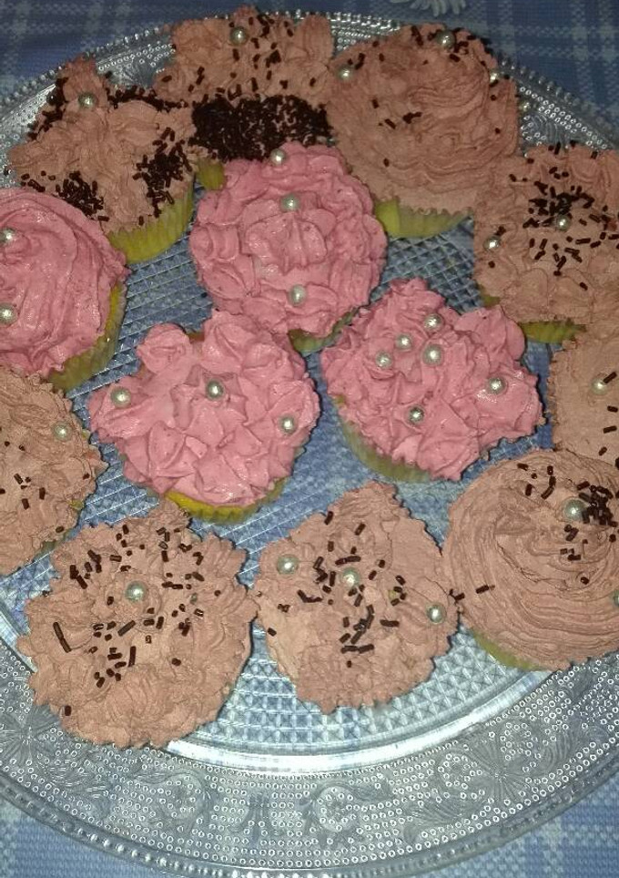 Una foto de Cupcakes relleno de crema de vainilla cubiertos con frosting de chocolate y mousse de fresa