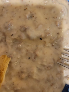 A picture of Sausage gravy and biscuits.