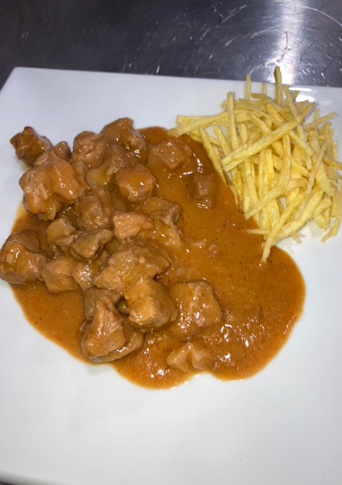 Una foto de Carne en salsa estilo granadino con patatas paja