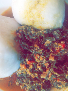 A picture of Tuwon shinkafa with egusi and shredded spinach.
