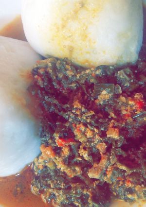 A picture of Tuwon shinkafa with egusi and shredded spinach.