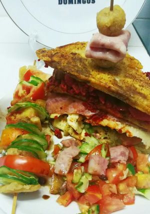 Una foto de Patacones con carnes ahumadas, queso de cabra y brochetas de vegetales