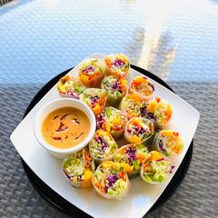 A picture of Rainbow Vegetables Rolls with Peanut Sriracha Dipping Sauce.